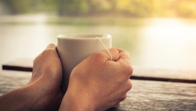 hands holding tea - summer lake glowing in background | the DAWN Method